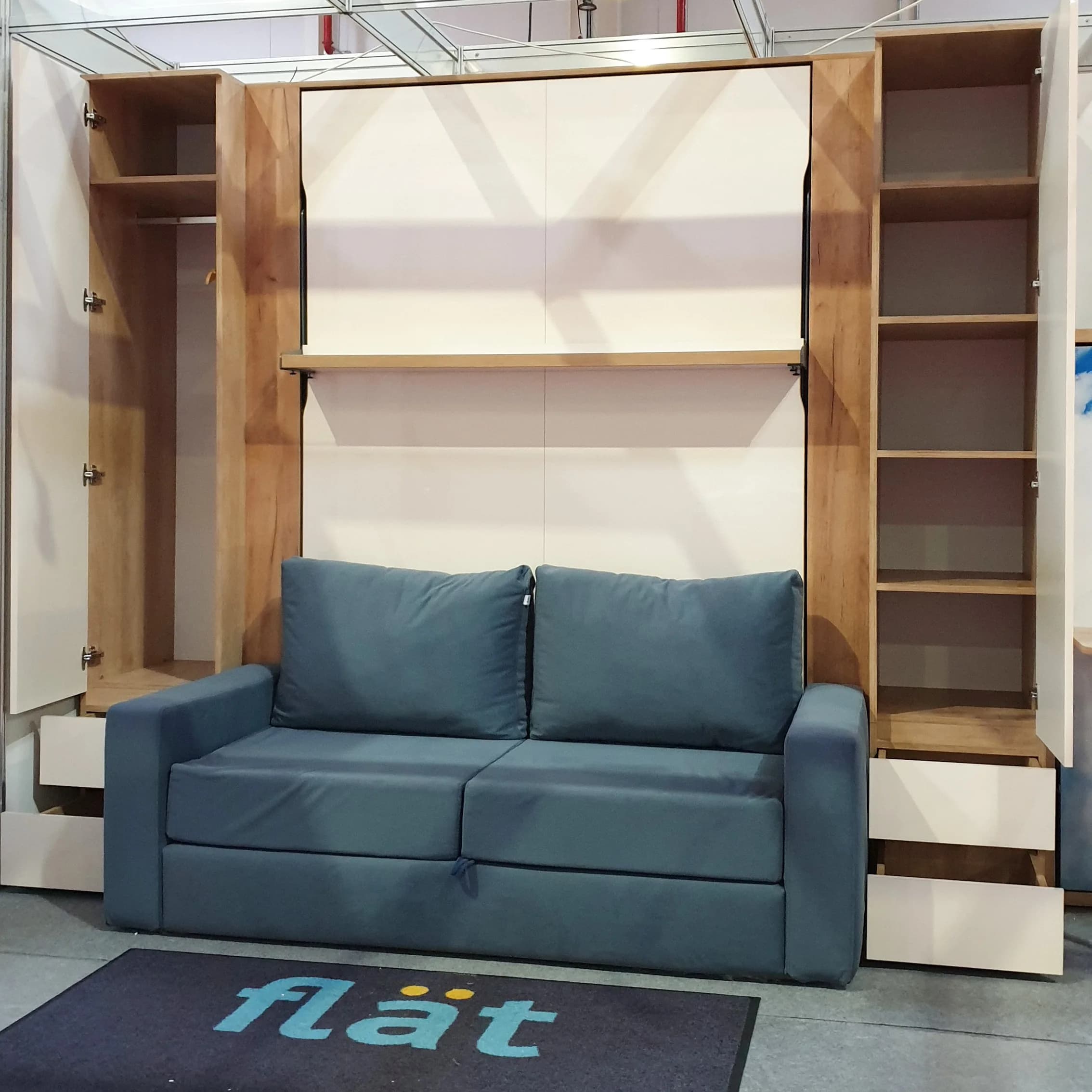The flät stand at Romexpo 2023: a closed wall bed with a blue sofa and wardrobes